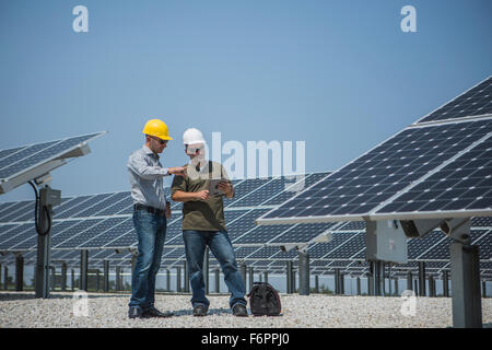 Les techniciens du Caucase parler près de panneaux solaires Banque D'Images