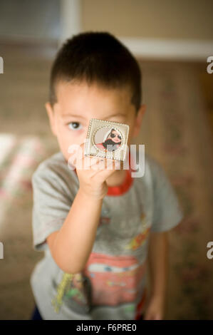 Les jeunes trois ans vieux garçon mexicain hispanique holding photo de lui-même. Banque D'Images