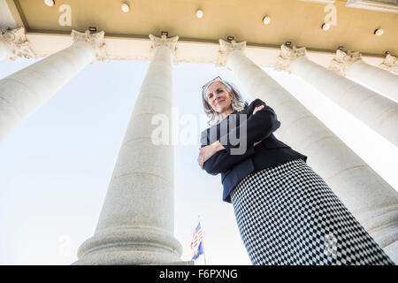 Low angle view of Caucasian businesswoman standing sous les colonnes Banque D'Images