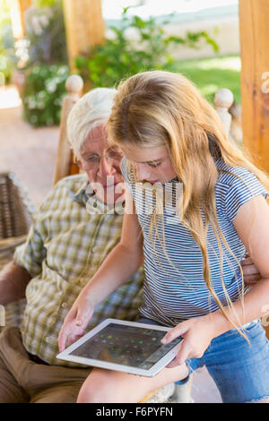 Grand-père et petite-fille de race blanche using digital tablet Banque D'Images