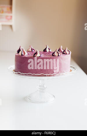 Vue latérale du beau gâteau maison lilas avec motif ethnique et merengues Banque D'Images