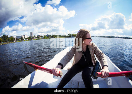 Caucasian woman rowing boat Banque D'Images