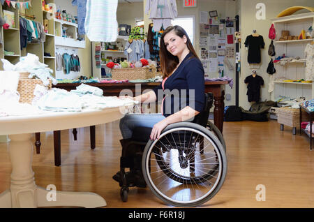 Femmes enceintes paraplegic woman in wheelchair shopping en magasin bébé Banque D'Images