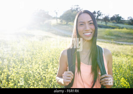 Mixed Race woman carrying backpack in field Banque D'Images