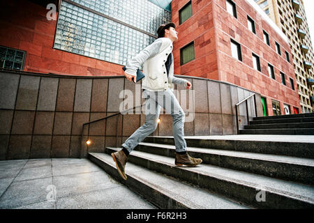 Caucasian businessman walking on steps Banque D'Images