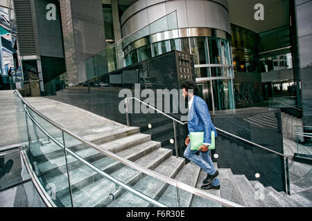 Mixed Race businessman carrying digital tablet Banque D'Images