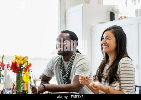 Couple smiling at table de salle à manger Banque D'Images