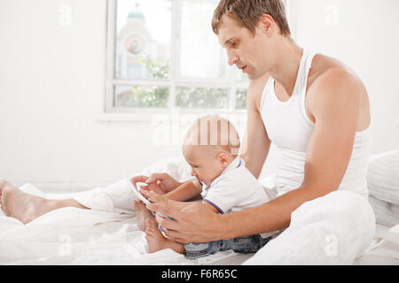 Jeune père et son fils âgé de neuf mois with digital tablet Banque D'Images