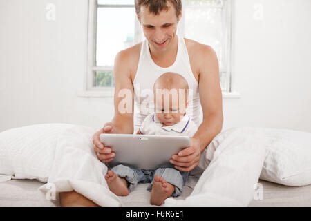 Jeune père et son fils âgé de neuf mois with digital tablet Banque D'Images