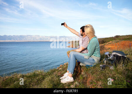 Young couple taking self portrait sur falaise Banque D'Images