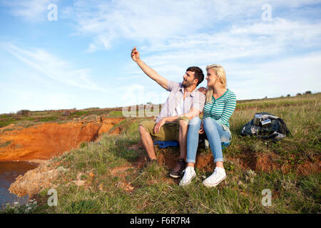 Young couple taking self portrait sur falaise Banque D'Images