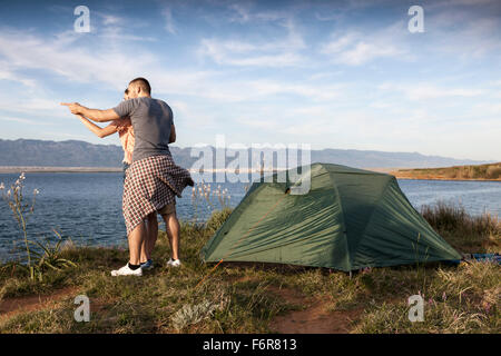 Jeune couple de camping sur le bord de l'eau Banque D'Images