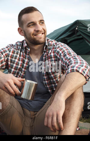 Jeune homme au camping rêver Banque D'Images