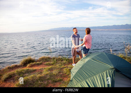 Jeune couple sur le bord de l'eau holding hands Banque D'Images