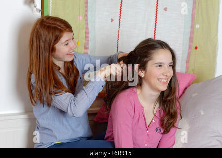 Les jeunes filles faisant leurs cheveux, tresses, Allemagne Banque D'Images