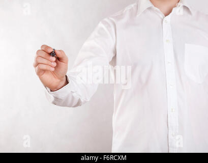 Jeune homme écrit avec marqueur noir. Chemin de détourage inclus. Banque D'Images