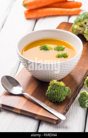 Crème de légumes soupe décoré avec des morceaux de chou-fleur, dans le bol blanc servi dans le restaurant de style eco table. Banque D'Images