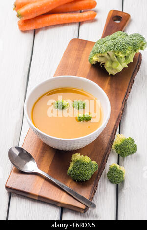 Crème de légumes soupe décoré avec des morceaux de chou-fleur, dans le bol blanc servi dans le restaurant de style eco table. Banque D'Images