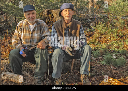 Les personnes âgées personnes âgées au repos des chasseurs et de prendre un verre après avoir travaillé dans les forêts du Québec, Canada Banque D'Images