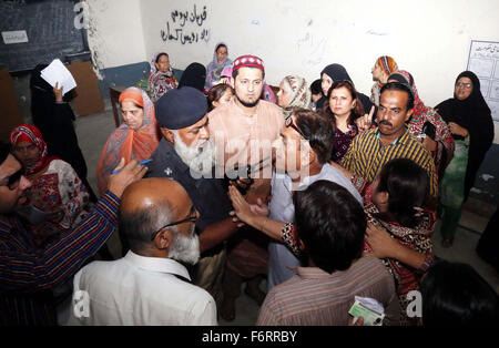 Des responsables de la sécurité et Présidents de bureau de vote clair essayer après l'affrontement entre les hommes et les électeurs au cours des élections locales (2015) à Hyderabad le Jeudi, Novembre 19, 2015. La deuxième phase des élections des organes locaux sont en cours dans 26 districts du Sindh et du Pendjab. Le scrutin a débuté à 7h30 et se poursuivra jusqu'à 17h30. Un certain nombre de plaintes ont été reçues de retard de l'interrogation pour misprinting des bulletins de vote. Banque D'Images