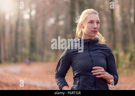 Jolie jeune femme fit marcher jusqu'à l'automne ou à l'automne approche forestiers l'appareil photo, Close up portrait du haut du corps en bonne santé Banque D'Images