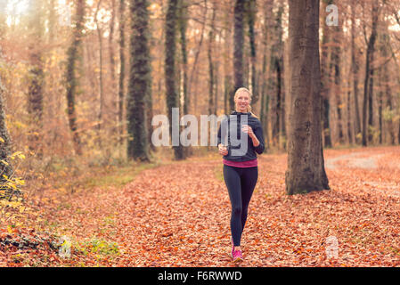 Jolie jeune femme fit marcher jusqu'à l'automne ou à l'automne approche forestiers l'appareil photo, Close up portrait du haut du corps en bonne santé Banque D'Images