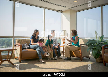 Doctor talking to patients en salle d'attente Banque D'Images