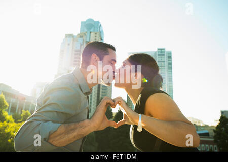 Hispanic couple kissing et décisions forme de coeur Banque D'Images