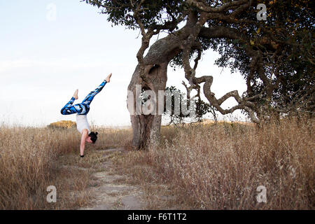 Caucasian woman practicing yoga in field Banque D'Images