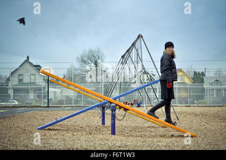 Caucasian woman walking on playground seesaw Banque D'Images