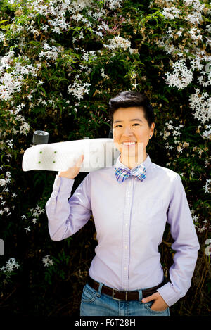 Femme androgyne holding skateboard Banque D'Images