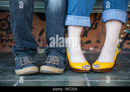 Close up de pieds de couple assis Banque D'Images