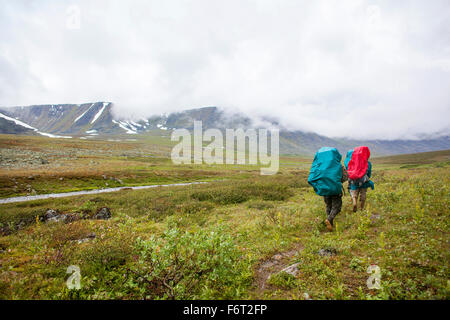 Backpackers marche sur chemin rural Banque D'Images