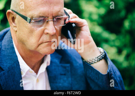 Hispanic businessman talking on cell phone Banque D'Images