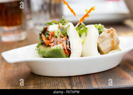 Petits pains cuits à la coréenne de porc avec avokado et kimchi Banque D'Images