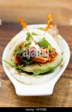 Petits pains cuits à la coréenne de porc avec avokado et kimchi Banque D'Images