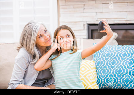 Grand-mère et petite-fille de race blanche en tenant avec selfies cell phone Banque D'Images