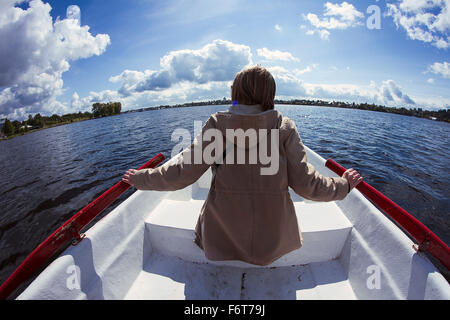 Caucasian woman rowing boat Banque D'Images