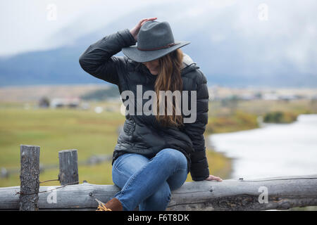 Caucasian woman sitting at rivière rural Banque D'Images