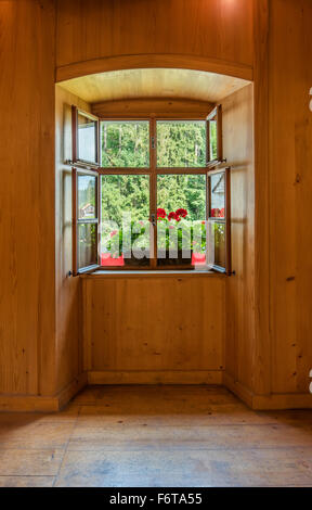Fenêtre ouverte avec des fleurs dans un intérieur en bois Banque D'Images