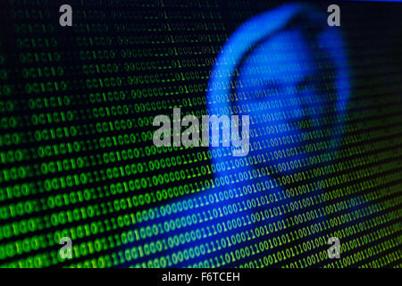 Un visage se reflète dans l'écran d'un ordinateur avec type binaire Banque D'Images