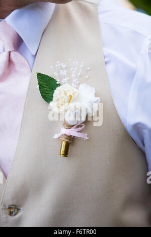 Balle de fusil cartouche avec une fleur attachée à un groom lors d'une cérémonie de mariage. Banque D'Images