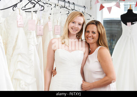 Mère Fille aidant à choisir en magasin nuptiale robe Banque D'Images