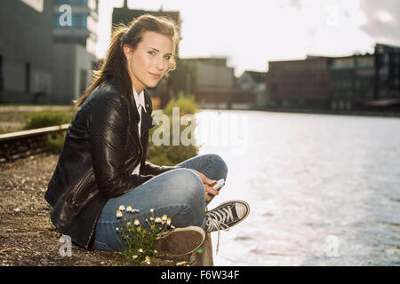 Allemagne, Munster, portrait of young woman relaxing at city Harbour Banque D'Images