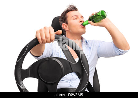 Portrait d'un jeune conducteur irresponsable au volant et de boire une bière isolé sur fond blanc Banque D'Images