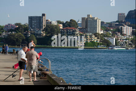 Des hommes plus âgés qui parlent et qui pêchent sur un quai à doigts à Walsh Bay sur le port de Sydney en Australie Banque D'Images