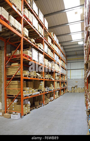 Un entrepôt de stockage modernes, avec des marchandises empilées sur les palettes sur rack haute Banque D'Images