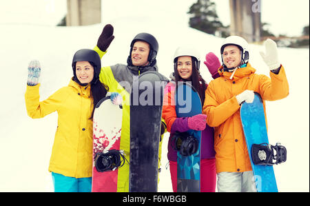 Happy friends dans casques avec snowboards Banque D'Images