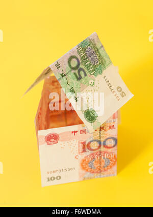 Maison faite de billets yuan chinois sur fond jaune Banque D'Images