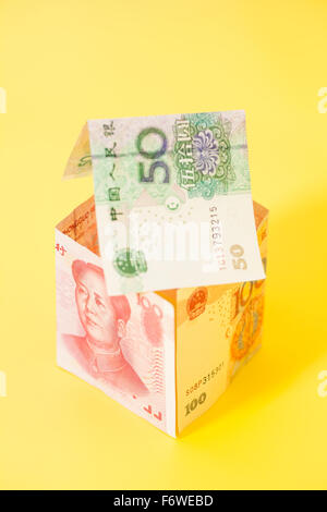 Maison faite de billets yuan chinois sur fond jaune Banque D'Images
